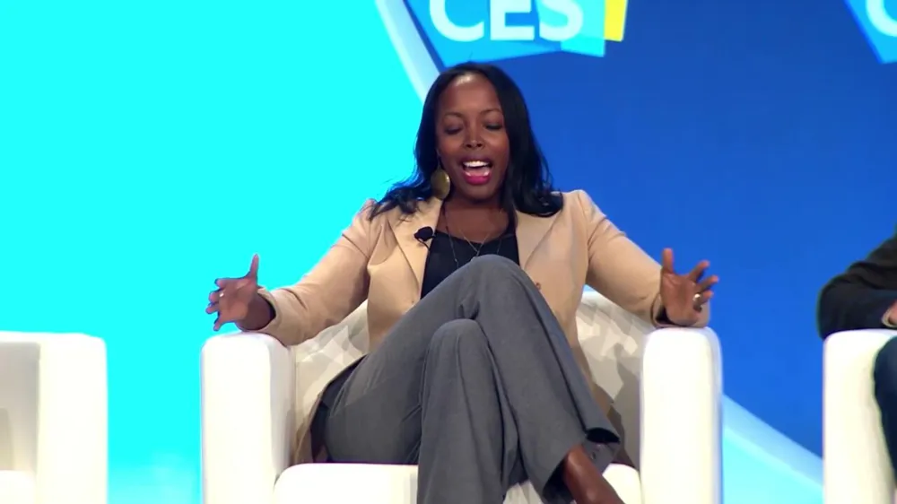 ALT Text: A woman sitting on stage talking about her work during CES